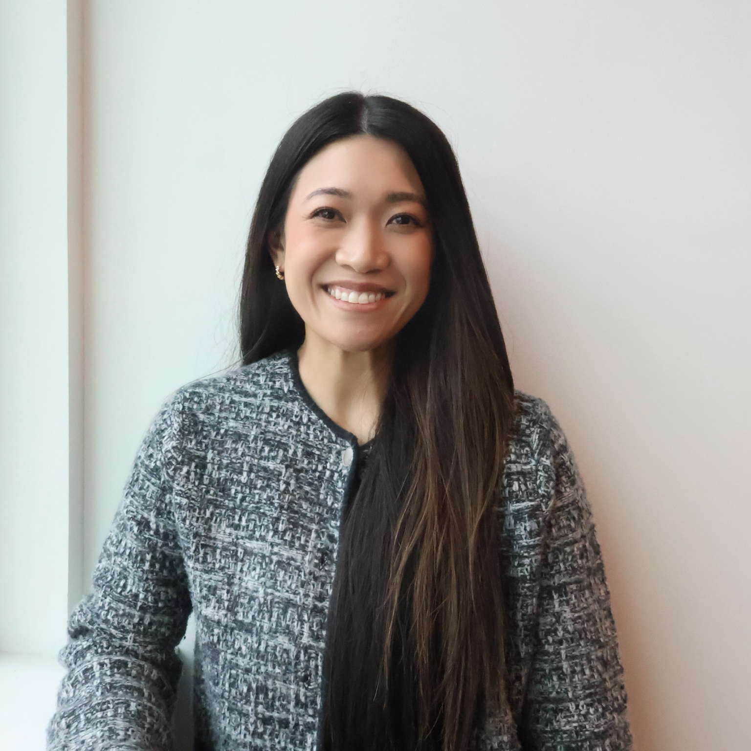 Staff member with long dark hair smiles into camera.